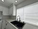 Close-up of the kitchen sink and countertops by the window, featuring modern black hardware at 6174 Meadowgrass Ln, Las Vegas, NV 89103