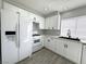 Bright kitchen featuring white cabinets, appliances, gray countertops, and modern black hardware at 6174 Meadowgrass Ln, Las Vegas, NV 89103