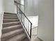 Staircase with carpeted steps and a black railing going up to the second level at 6174 Meadowgrass Ln, Las Vegas, NV 89103
