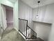 View from the top of a carpeted staircase looking down, featuring a modern light fixture at 6174 Meadowgrass Ln, Las Vegas, NV 89103