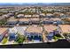 Expansive aerial view of a residential neighborhood with tile-roofed homes, palm trees, and mountain views at 6655 Tranquil Seas Ct, Las Vegas, NV 89139