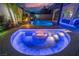 Custom backyard boasts a beautiful pool, waterfall feature, covered bar, and cozy fire pit at twilight at 6655 Tranquil Seas Ct, Las Vegas, NV 89139