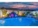 Custom backyard boasts a beautiful pool and waterfall feature at twilight at 6655 Tranquil Seas Ct, Las Vegas, NV 89139