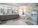 Spa-like bathroom featuring a soaking tub, a walk-in shower, marble accents, and a double vanity sink at 6655 Tranquil Seas Ct, Las Vegas, NV 89139