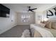 A well-lit bedroom features carpeted floors, a ceiling fan, and stylish decor at 6655 Tranquil Seas Ct, Las Vegas, NV 89139