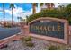 Pinnacle One community sign surrounded by stone and lush landscaping with palm trees and blue skies at 6655 Tranquil Seas Ct, Las Vegas, NV 89139