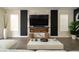 Contemporary living room with a fireplace, a large television, modern decor, and hardwood flooring at 6655 Tranquil Seas Ct, Las Vegas, NV 89139