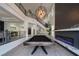 Bright open-plan living room with a billiard table, modern fireplace, and staircase to the upper level at 6655 Tranquil Seas Ct, Las Vegas, NV 89139