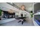Spacious living room with high ceilings, featuring a billiards table, fireplace and staircase at 6655 Tranquil Seas Ct, Las Vegas, NV 89139