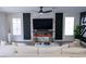 Modern living room featuring a fireplace, large TV, and white sofa set, creating an ideal relaxation space at 6655 Tranquil Seas Ct, Las Vegas, NV 89139