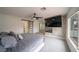 Bright primary bedroom with a ceiling fan, a wall-mounted TV, fireplace, and an ensuite bathroom at 6655 Tranquil Seas Ct, Las Vegas, NV 89139