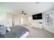 Bright main bedroom with a ceiling fan, large TV, and easy access to the ensuite bathroom at 6655 Tranquil Seas Ct, Las Vegas, NV 89139