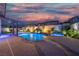 Beautiful backyard pool featuring rock waterfall, lush landscaping, and evening sky at 6655 Tranquil Seas Ct, Las Vegas, NV 89139