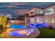 Inviting pool area featuring a waterfall, a fire pit, and an outdoor bar with stylish blue accent lighting at 6655 Tranquil Seas Ct, Las Vegas, NV 89139