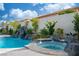 Backyard pool with rock waterfall, hot tub, and lush landscaping, perfect for outdoor enjoyment at 6655 Tranquil Seas Ct, Las Vegas, NV 89139