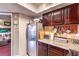 Kitchen featuring stainless steel appliances and dark wood cabinetry with a peek into the living room at 6800 E Lake Mead Blvd # 2107, Las Vegas, NV 89156