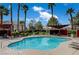 Community pool surrounded by lush landscaping, palm trees, and comfortable lounge chairs at 7885 W Flamingo Rd # 2012, Las Vegas, NV 89147