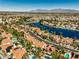 This aerial showcases residential area with the serene lake, offering homes with lush landscaping and mountain views at 8433 Honeywood Cir, Las Vegas, NV 89128