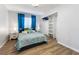 Cozy bedroom features a comfortable bed, bright blue curtains, and a convenient closet with shelving at 8433 Honeywood Cir, Las Vegas, NV 89128