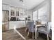 Inviting breakfast nook with natural light, wood table and chairs and updated glass front cabinetry at 8433 Honeywood Cir, Las Vegas, NV 89128