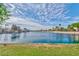 Scenic view of a wide lake with palm trees and houses in the background on a beautiful sunny day at 8433 Honeywood Cir, Las Vegas, NV 89128