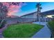 A backyard featuring a well-maintained lawn, patio area, and block wall fencing, providing privacy and space at 8512 Porch Rocker St, Las Vegas, NV 89143