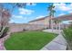 A backyard featuring a well-maintained lawn, patio area, and block wall fencing, providing privacy and space at 8512 Porch Rocker St, Las Vegas, NV 89143