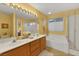 Bright bathroom featuring a double sink vanity, separate shower, and soaking tub, illuminated by vanity lights and natural light at 8512 Porch Rocker St, Las Vegas, NV 89143