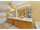 Bright bathroom featuring a double sink vanity, sliding mirrored closet, separate shower, and soaking tub, illuminated by vanity lights at 8512 Porch Rocker St, Las Vegas, NV 89143