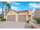 The exterior of this home features a two car garage, desert landscaping, and manicured lawn at 8512 Porch Rocker St, Las Vegas, NV 89143