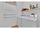 Efficient laundry room featuring modern appliances and a convenient shelf for storage at 8512 Porch Rocker St, Las Vegas, NV 89143