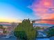 Mountain view behind lush tree with pink, orange, and blue sky at twilight at 8512 Porch Rocker St, Las Vegas, NV 89143