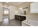 Bright bathroom featuring a soaking tub, wood look flooring and a large mirror at 907 Gallery Course Dr, Las Vegas, NV 89148