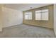 Large bedroom with neutral carpeting, a ceiling light and two sunlit windows with blinds at 907 Gallery Course Dr, Las Vegas, NV 89148
