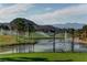 Picturesque golf course with a water feature, framed by palm trees and distant mountain views at 907 Gallery Course Dr, Las Vegas, NV 89148