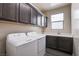 Convenient laundry room with modern appliances, countertop, and built-in cabinets at 907 Gallery Course Dr, Las Vegas, NV 89148