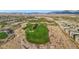 Amazing aerial view of a vibrant golf course community with a serene lake, lush green fairways, and stunning desert landscape at 9144 Las Manaitas Ave # 201, Las Vegas, NV 89144