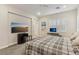 Bright bedroom featuring a large bed, a wall-mounted TV, and a window with shutters, creating a cozy space at 9144 Las Manaitas Ave # 201, Las Vegas, NV 89144