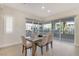 Bright dining area with a rustic wood table, neutral chairs, and sliding glass doors to a balcony at 9144 Las Manaitas Ave # 201, Las Vegas, NV 89144