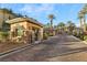 Elegant gated community entrance with palm trees and lush landscaping offers security and curb appeal at 9144 Las Manaitas Ave # 201, Las Vegas, NV 89144