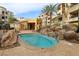 Inviting hot tub with a rock waterfall and lounge chairs offers a peaceful spa-like experience at 9144 Las Manaitas Ave # 201, Las Vegas, NV 89144