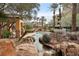 Relaxing hot tub surrounded by lush landscaping and rocks, perfect for unwinding and serenity at 9144 Las Manaitas Ave # 201, Las Vegas, NV 89144