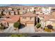 View of two-story home with tile roof, stone accents, manicured landscaping, and driveway at 9869 White Lilac St, Las Vegas, NV 89178