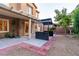 Backyard with concrete patio, built-in island bar, small shed and green foliage at 9869 White Lilac St, Las Vegas, NV 89178