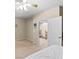 Bright bedroom featuring neutral carpet, ceiling fan, and doorway leading to the staircase at 9869 White Lilac St, Las Vegas, NV 89178