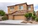 Attractive two-story home featuring a stone facade, three-car garage, manicured landscaping, and desert rock accents at 9869 White Lilac St, Las Vegas, NV 89178