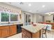 Open kitchen with granite island, tile floors and sliding glass doors to access the backyard at 9869 White Lilac St, Las Vegas, NV 89178