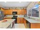 Bright kitchen with ample cabinet space, granite countertops, and modern black appliances at 9869 White Lilac St, Las Vegas, NV 89178