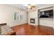 Inviting living area with hardwood floors, a stone fireplace, and neutral walls for a cozy ambiance at 9869 White Lilac St, Las Vegas, NV 89178