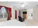 Spacious main bedroom featuring carpet flooring, a ceiling fan, and a comfy chair at 9869 White Lilac St, Las Vegas, NV 89178
